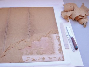 Removing the later strawboard backing using a scalpel, letter opener and spatula